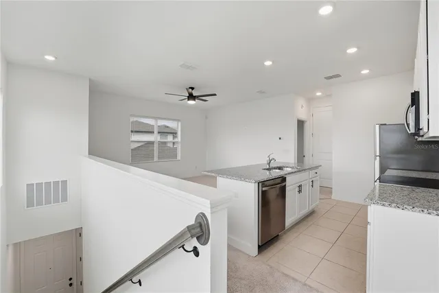 a kitchen with stainless steel appliances granite countertop a sink and a stove