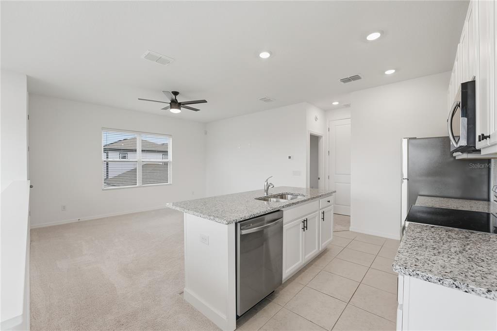 6552 Barnstorm Way St. Cloud, FL 34771 - Photo 3 of 17 a kitchen with a sink and a stove top oven with wooden floor