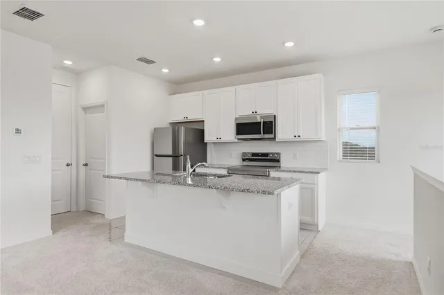 a kitchen with stainless steel appliances granite countertop a sink and a stove