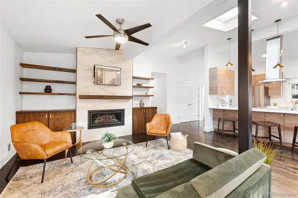 a living room with furniture a fireplace and a large window