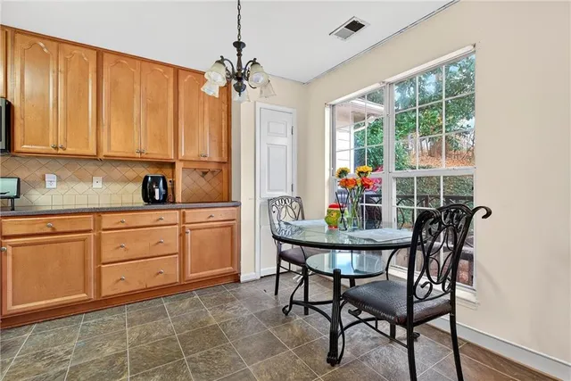 a kitchen with stainless steel appliances a dining table chairs and chandelier