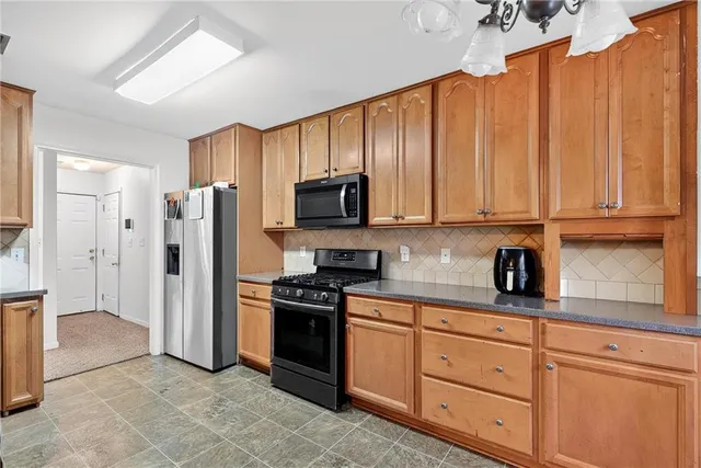 a kitchen with stainless steel appliances granite countertop a refrigerator and cabinets