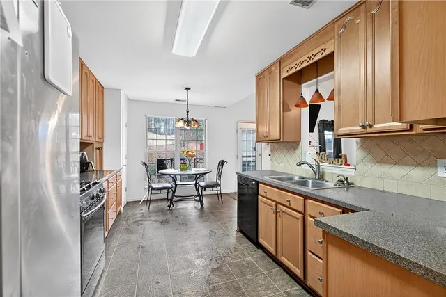 a kitchen with granite countertop a sink stove and refrigerator