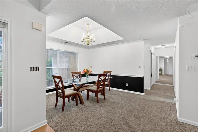 a view of a dining room with furniture and chandelier