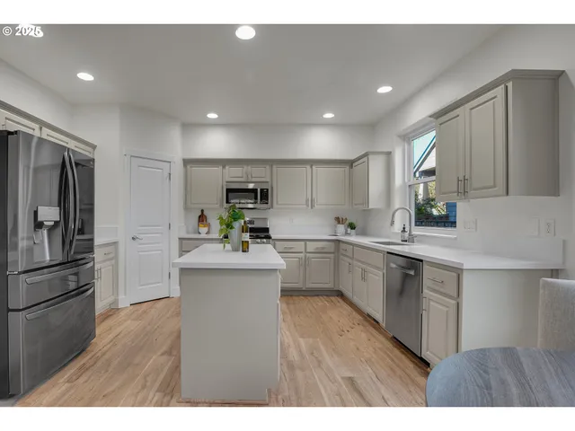 a kitchen with white cabinets and stainless steel appliances