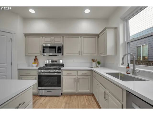 a kitchen with cabinets stainless steel appliances a sink and a counter top space