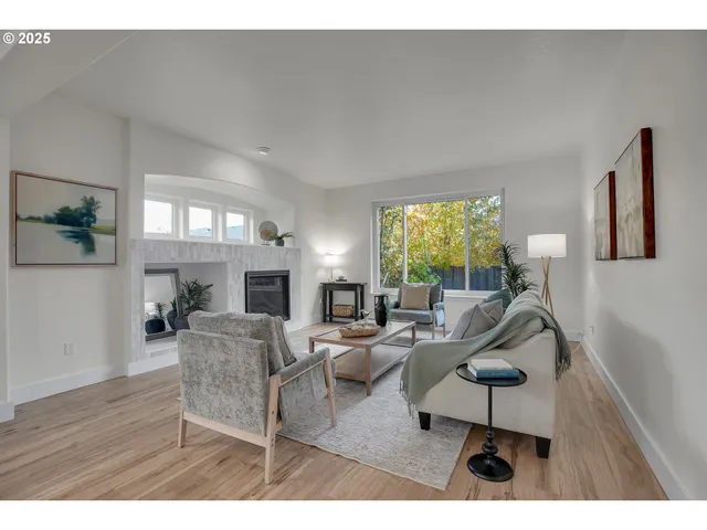 a living room with fireplace furniture and a large window