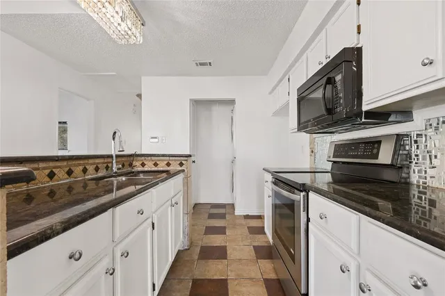 a kitchen with stainless steel appliances a sink stove and cabinets