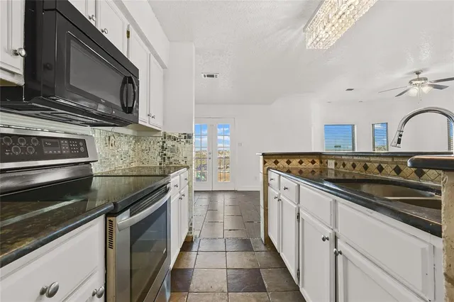 a kitchen with stainless steel appliances granite countertop a stove and a microwave