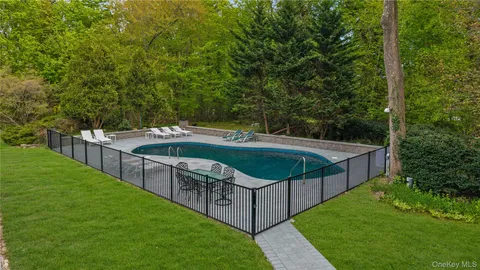 a view of a deck and yard with green space and seating area