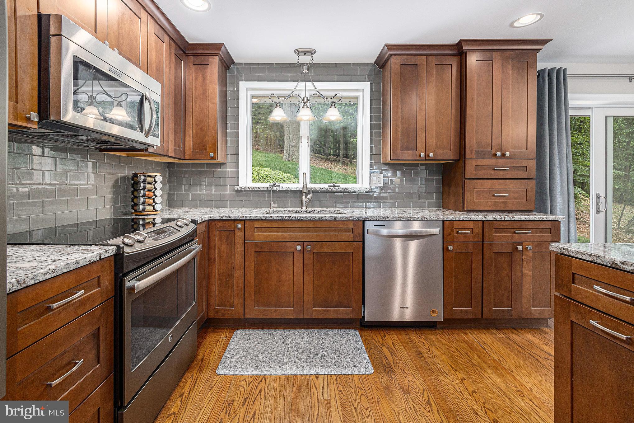 556 Forest Road Wayne, PA 19087 - Photo 9 of 35 a kitchen with stainless steel appliances granite countertop a stove a sink and a microwave