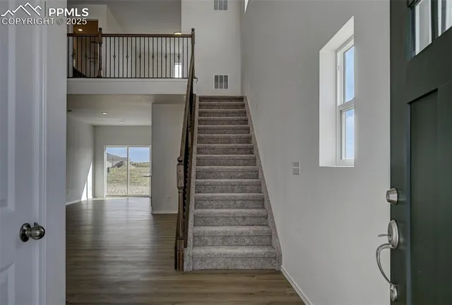 a view of entryway and hall with wooden floor