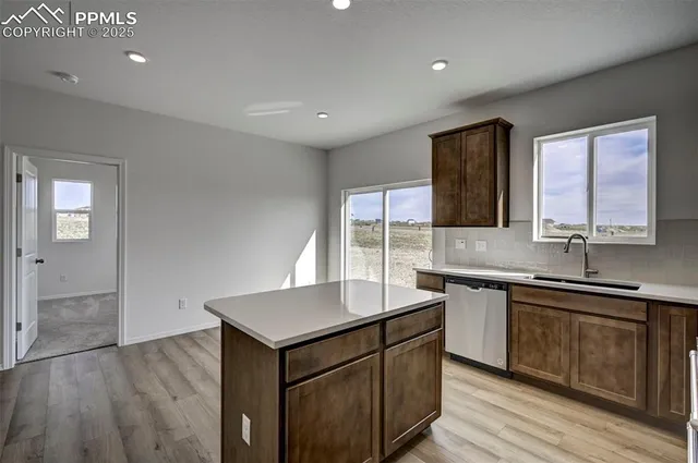 a kitchen with a sink cabinets and wooden floor