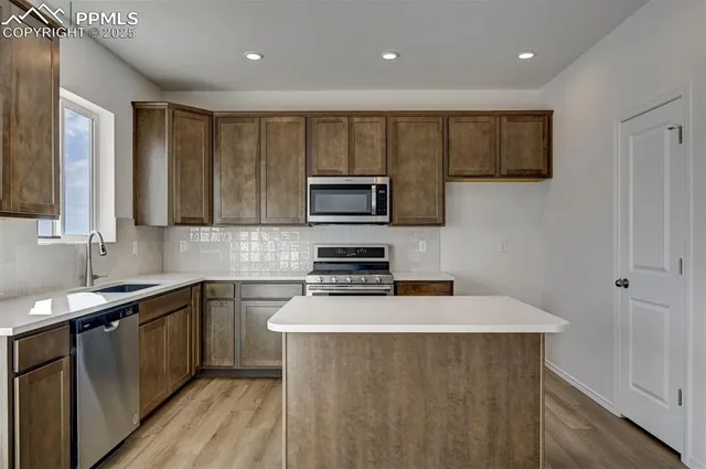 a kitchen with stainless steel appliances a stove sink microwave and cabinets