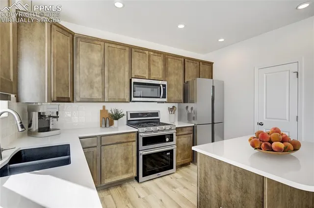 a kitchen with stainless steel appliances a stove refrigerator sink and microwave