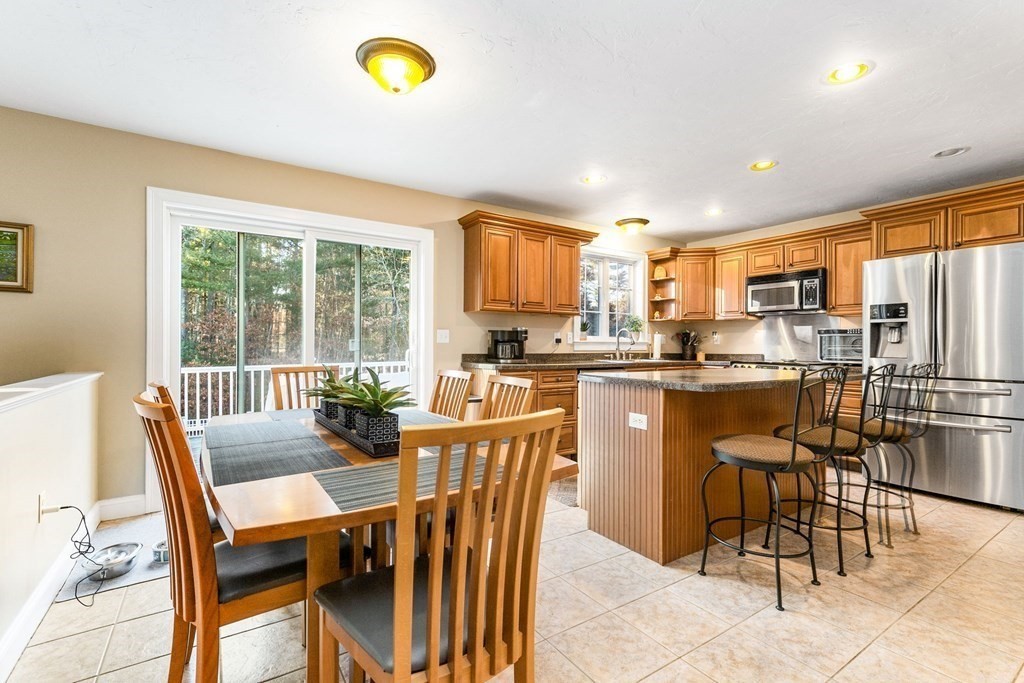 47 Mayflower Lane Rochester, MA 02770 - Photo 17 of 40 a dining room with stainless steel appliances a dining table chairs and granite counter tops