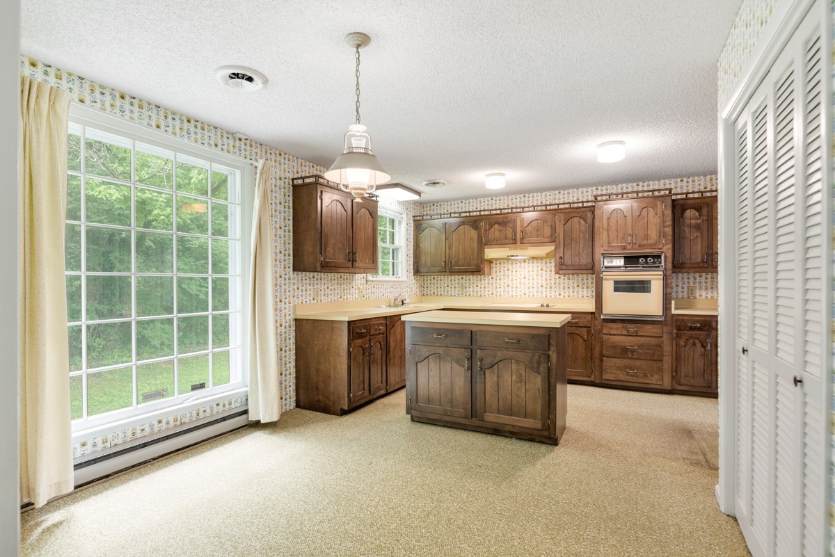 6908 River Rd Pike Nashville, TN 37209 - Photo 18 of 47 a large kitchen with kitchen island a large counter top space a sink stainless steel appliances and cabinets