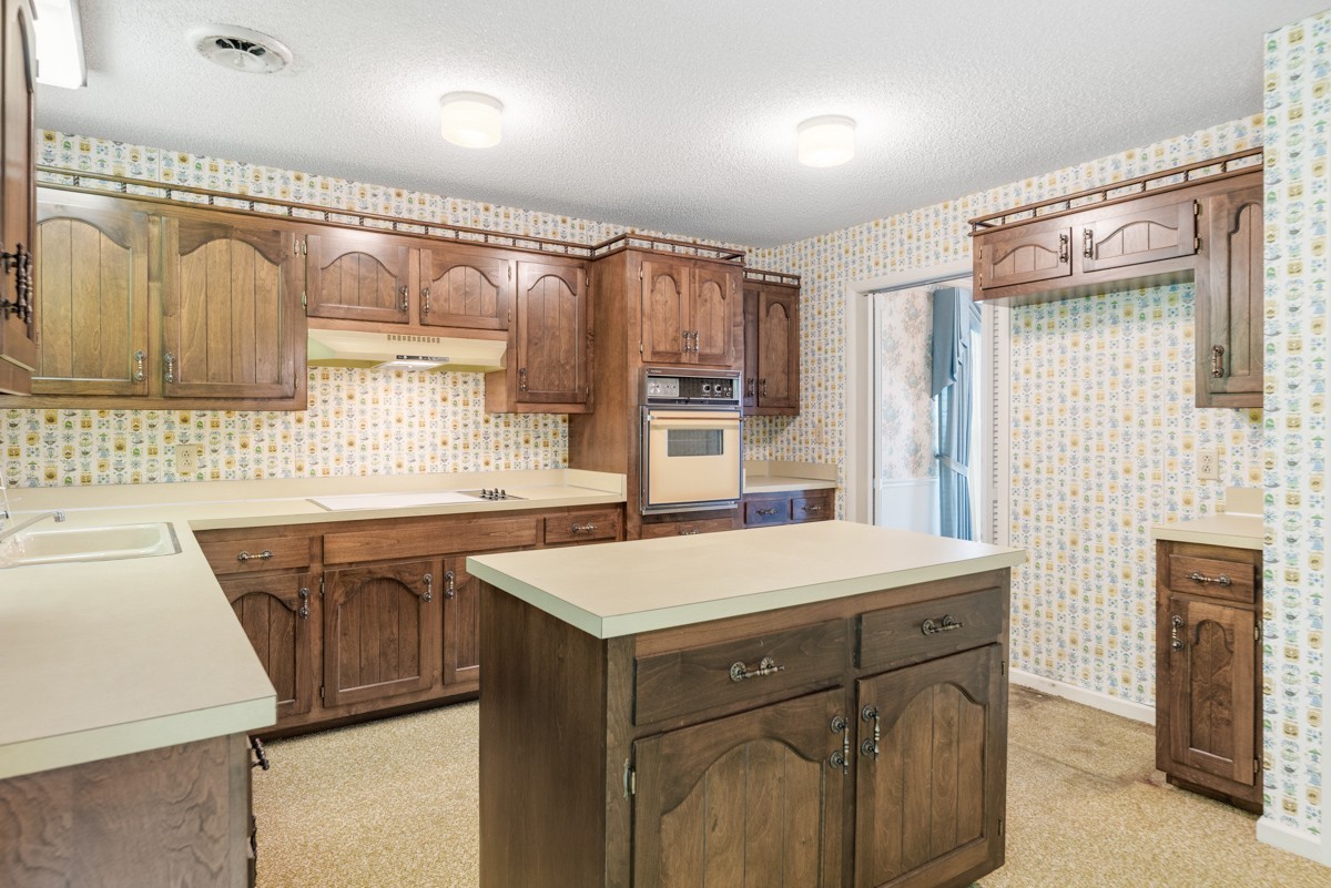6908 River Rd Pike Nashville, TN 37209 - Photo 22 of 47 a kitchen that has a sink a stove and a table in it