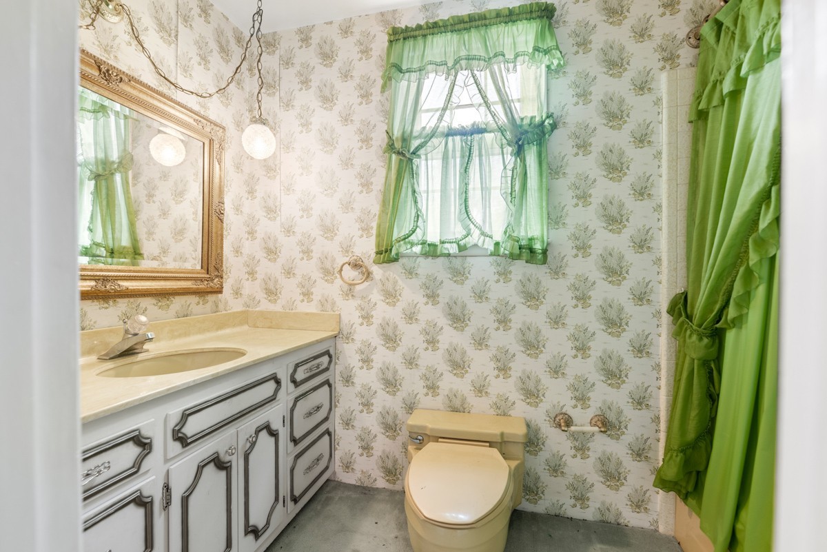 6908 River Rd Pike Nashville, TN 37209 - Photo 27 of 47 a bathroom with a granite countertop sink a toilet and a window