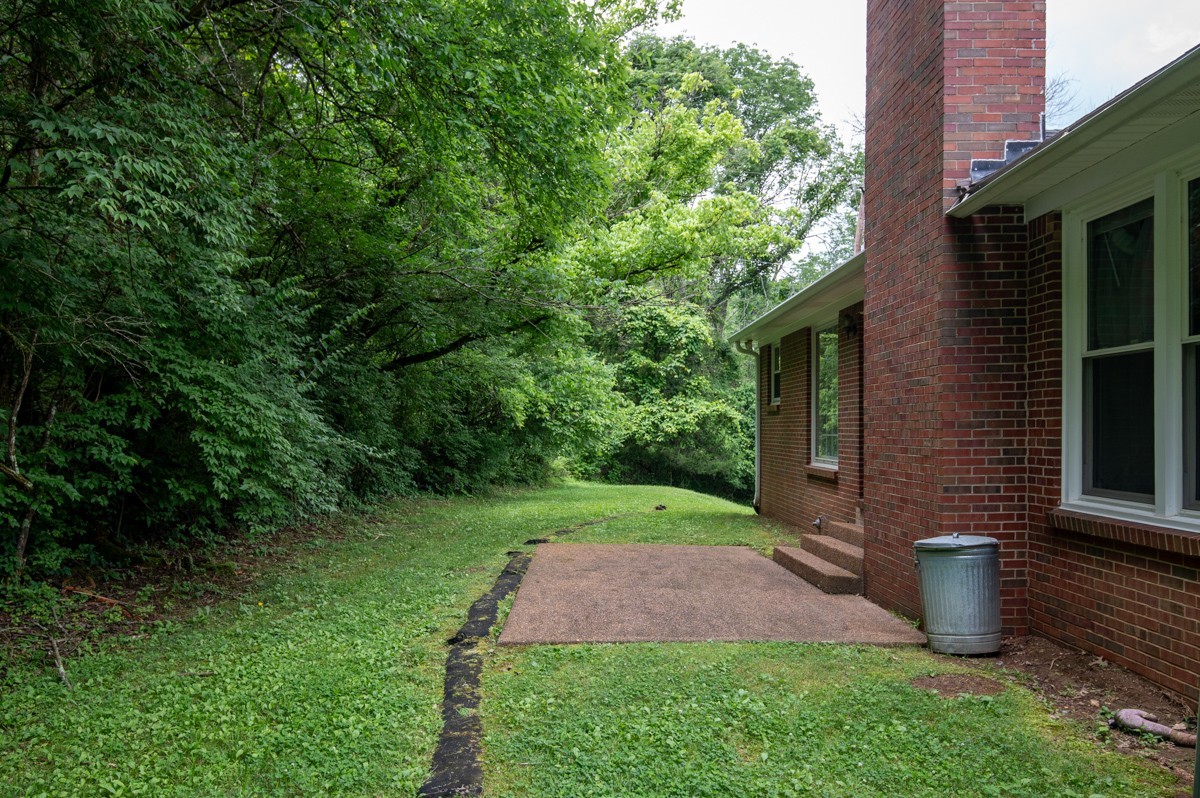 6908 River Rd Pike Nashville, TN 37209 - Photo 39 of 47 a view of a backyard with table and chairs plants and large tree