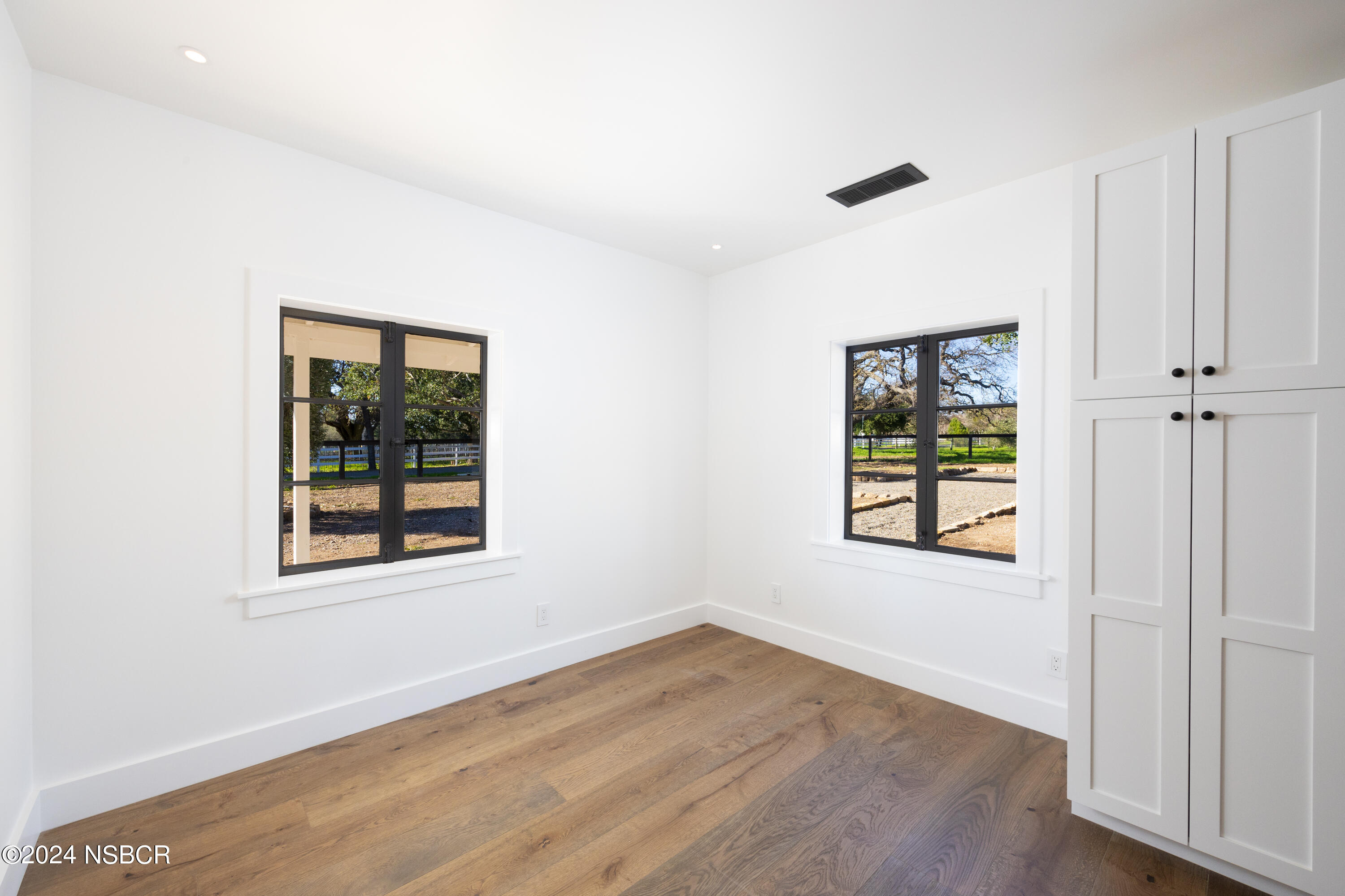 2380 North Refugio Road Santa Ynez, CA 93460 - Photo 14 of 38 an empty room with wooden floor and windows