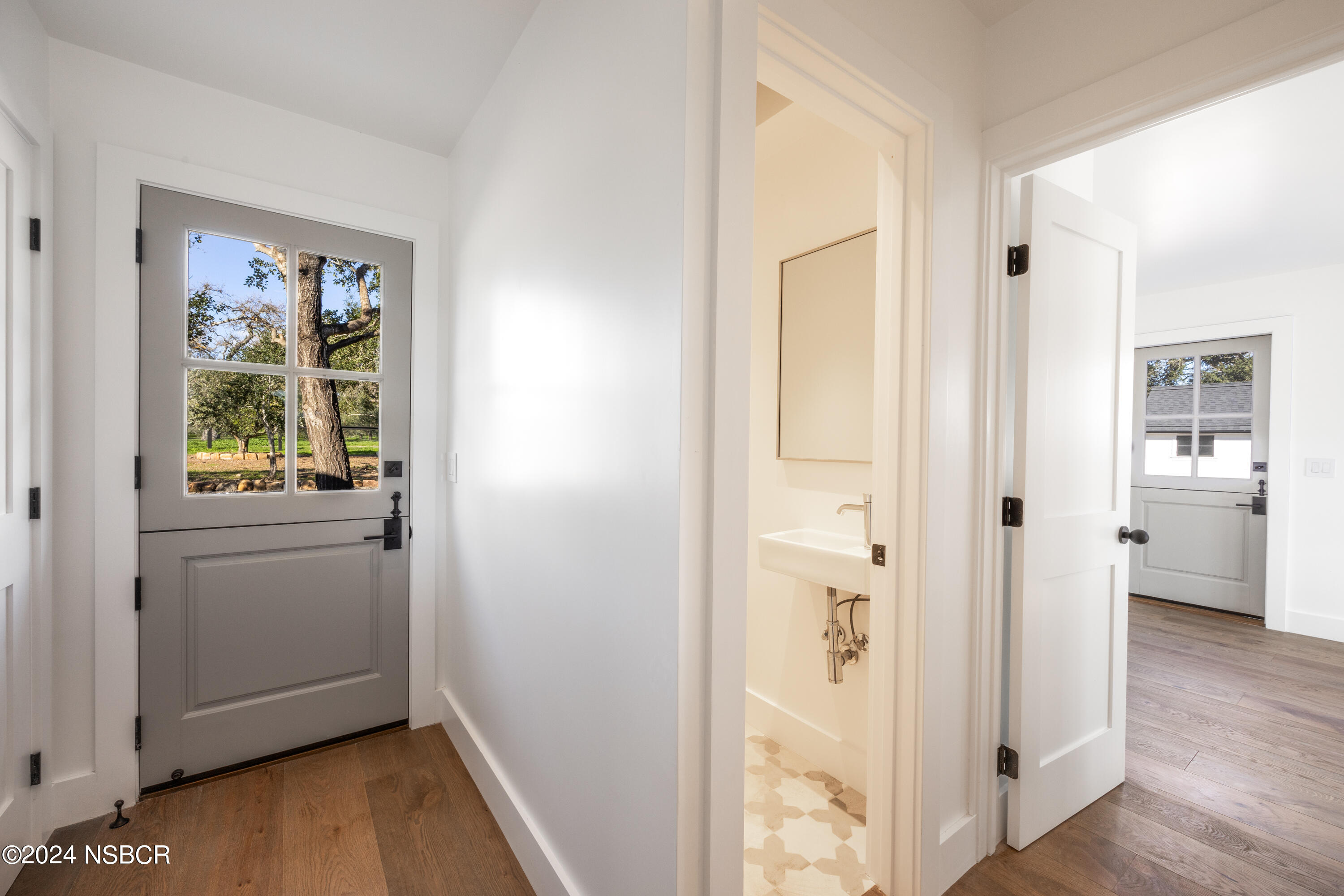 2380 North Refugio Road Santa Ynez, CA 93460 - Photo 21 of 38 a view of a hallway with wooden floor and a living room