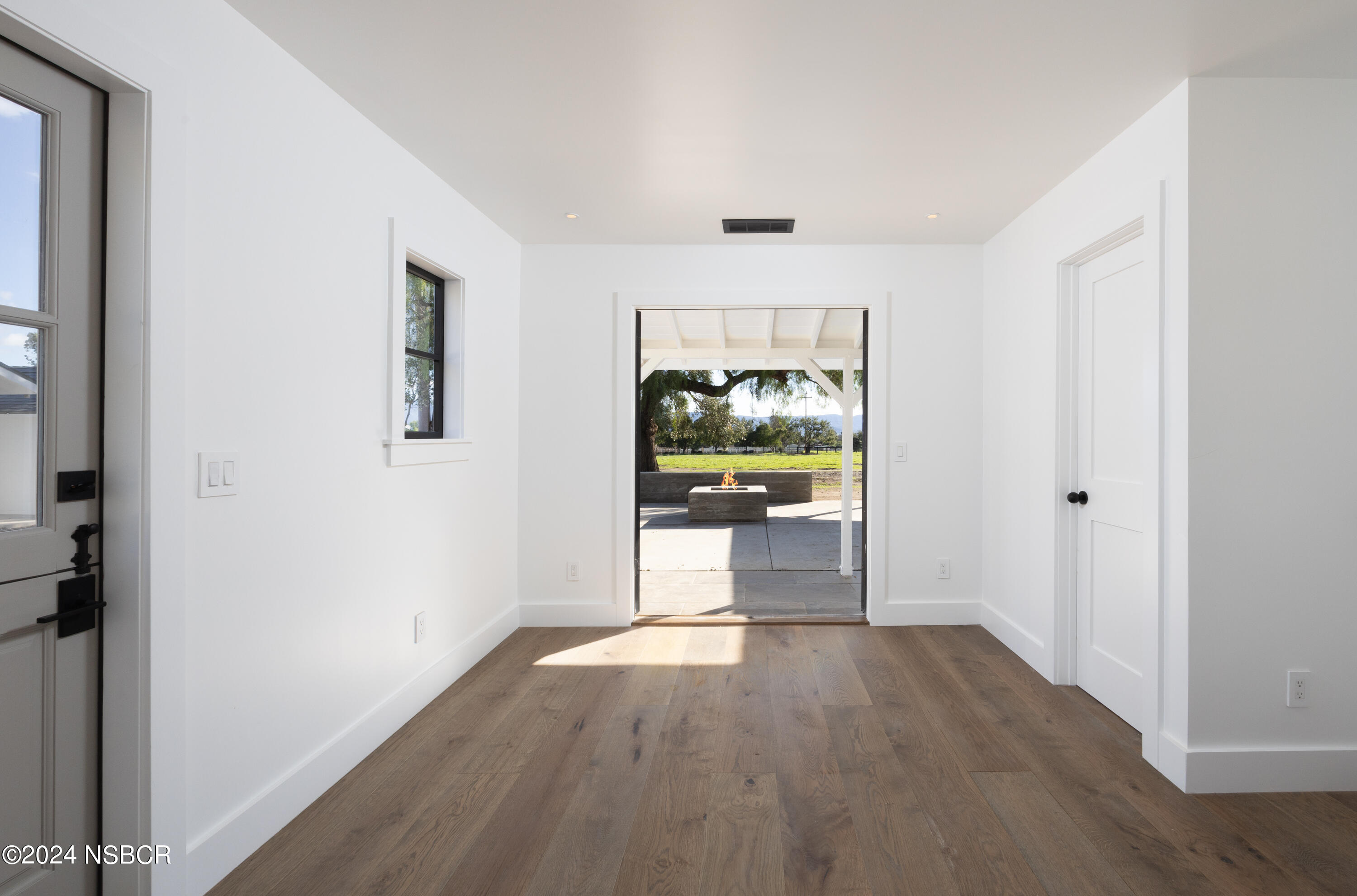 2380 North Refugio Road Santa Ynez, CA 93460 - Photo 23 of 38 a view of a hallway with wooden floor and a living room
