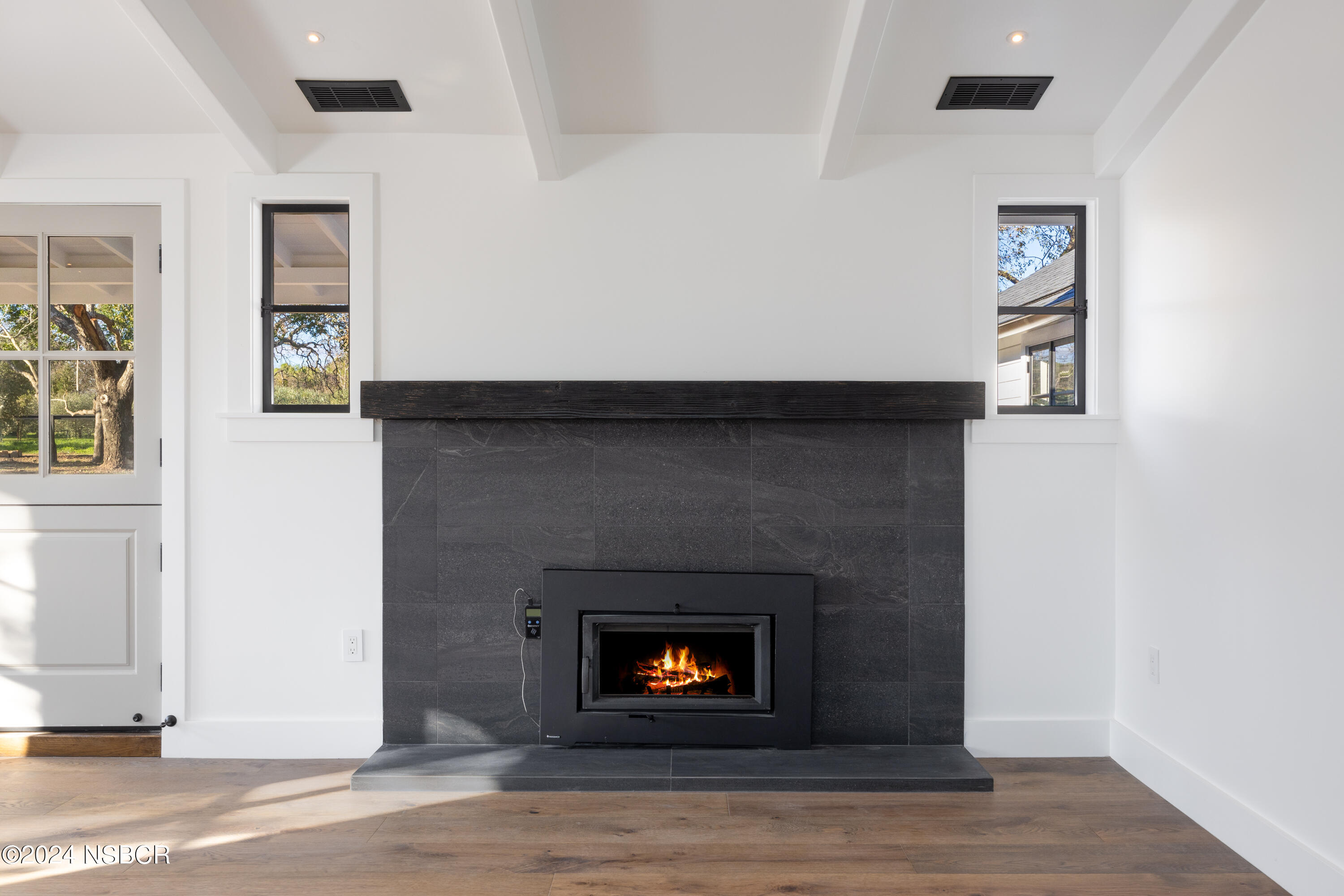 2380 North Refugio Road Santa Ynez, CA 93460 - Photo 27 of 38 a living room with a fireplace and a wooden floor