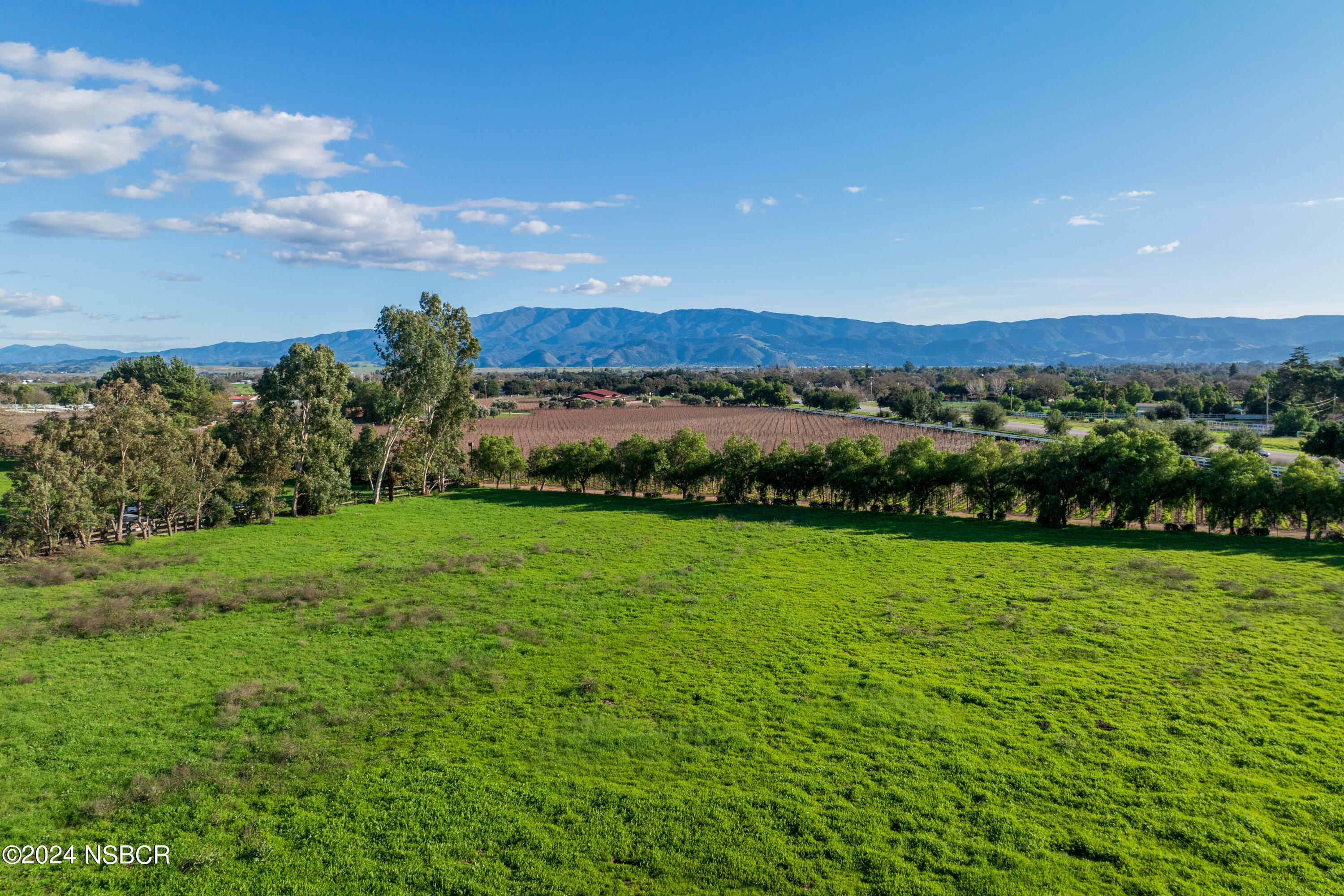 2380 North Refugio Road Santa Ynez, CA 93460 - Photo 36 of 38 a view of a lush green outdoor space with a swimming pool and valleys in the background