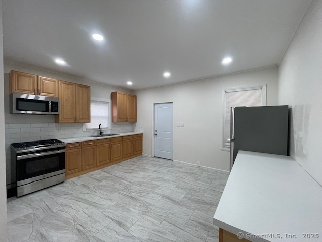 a kitchen with stainless steel appliances granite countertop a stove a sink and a refrigerator