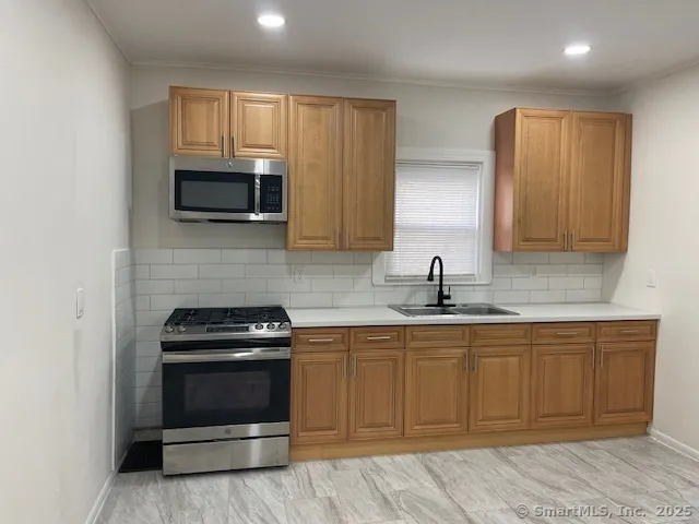 a kitchen with sink a microwave and cabinets