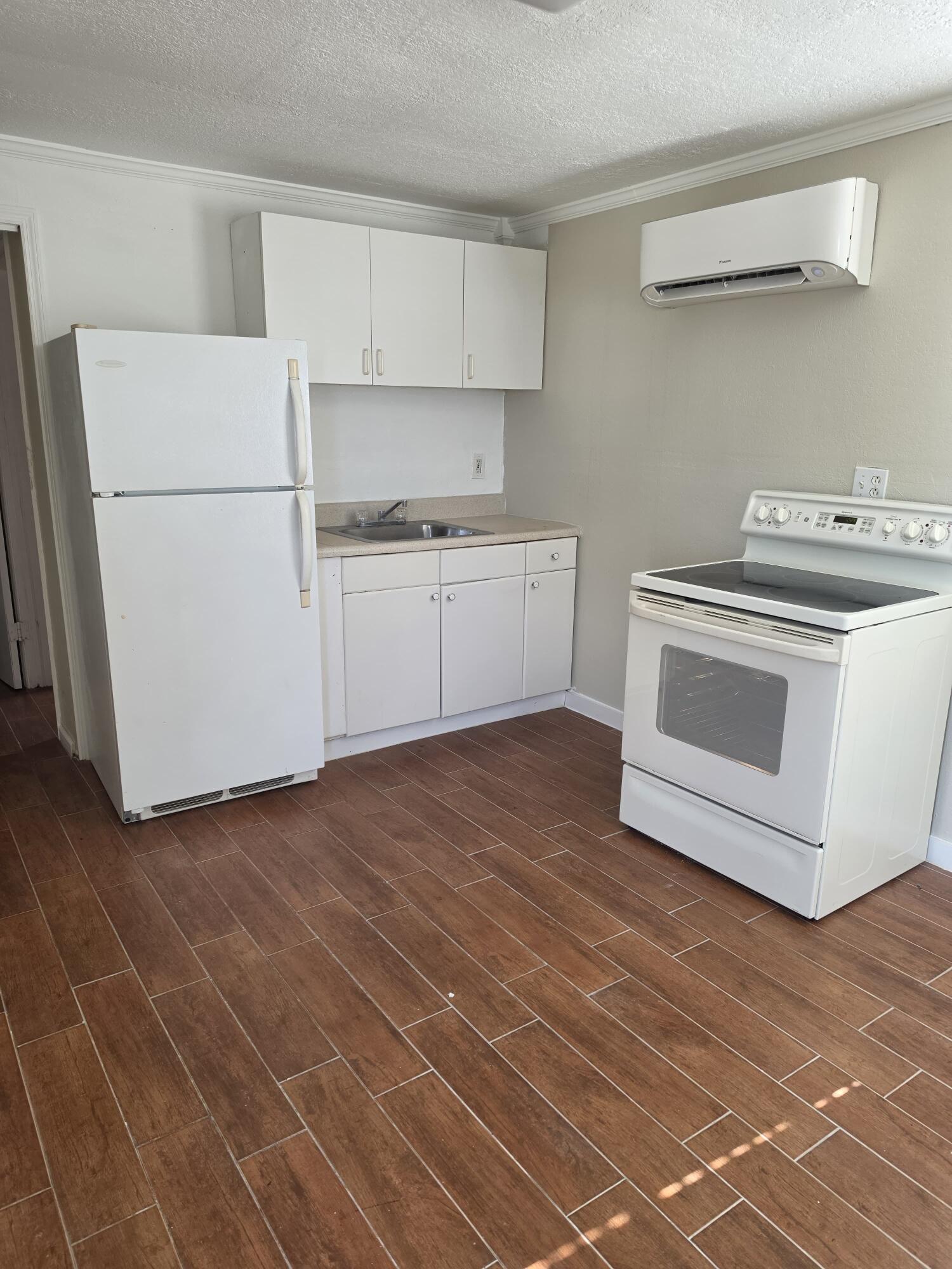5935 Taft Street, Unit 1 Hollywood, FL 33021 - Photo 1 of 9 a kitchen with a stove cabinets and wooden floor