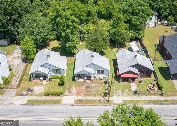 an aerial view of residential houses with outdoor space and street view