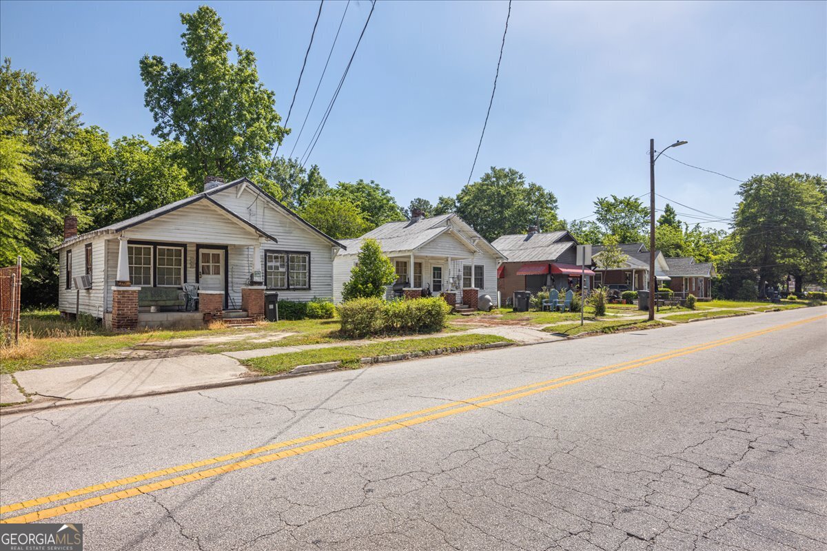 1377 Wrightsboro Road Augusta, GA 30901 - Photo 15 of 49 a front view of a house with a yard and table and chairs under an umbrella