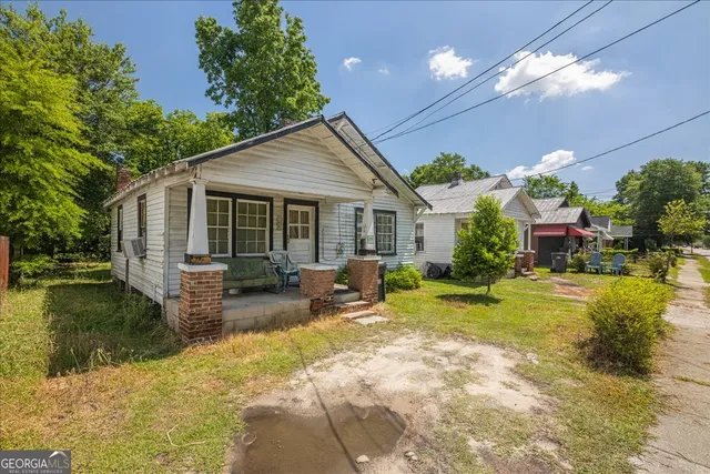 a view of a house with backyard and sitting area