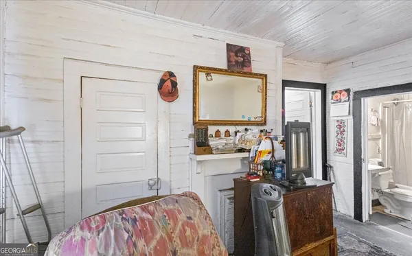 a view of a bedroom with a bed and a flat tv screen