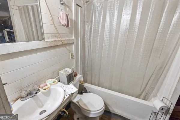 a bathroom with a sink a toilet and shower curtain