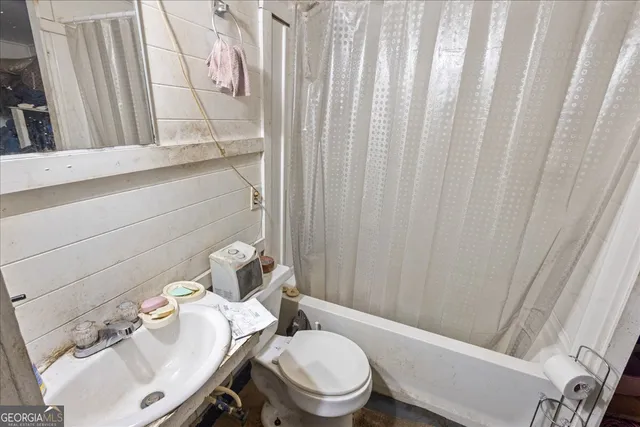 a bathroom with a sink a toilet and shower curtain