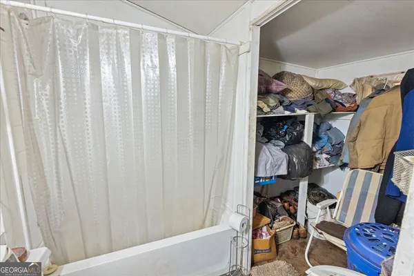 a view of walk in closet with clothes and shoes