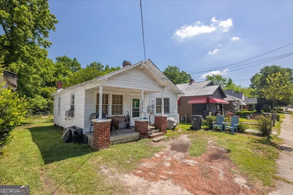 a view of a house with a yard patio and fire pit