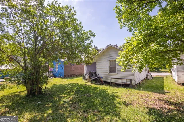 a view of a house with a yard and tree