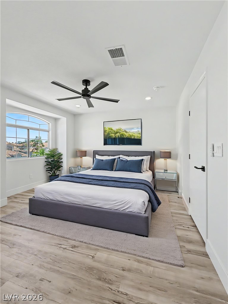 8977 Paige Rene Court Las Vegas, NV 89117 - Photo 17 of 31 A well-lit bedroom features a large arched window and a contemporary ceiling fan for comfort.