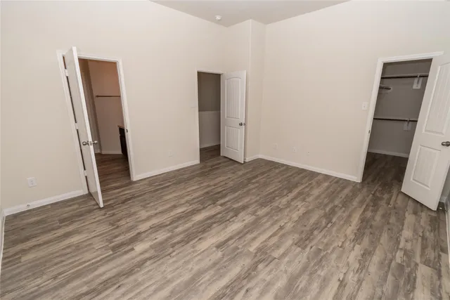 an empty room with wooden floor and a sink