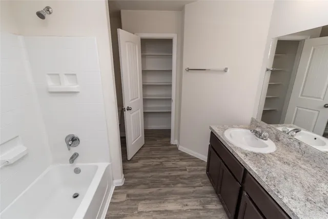 a bathroom with a granite countertop tub sink and mirror