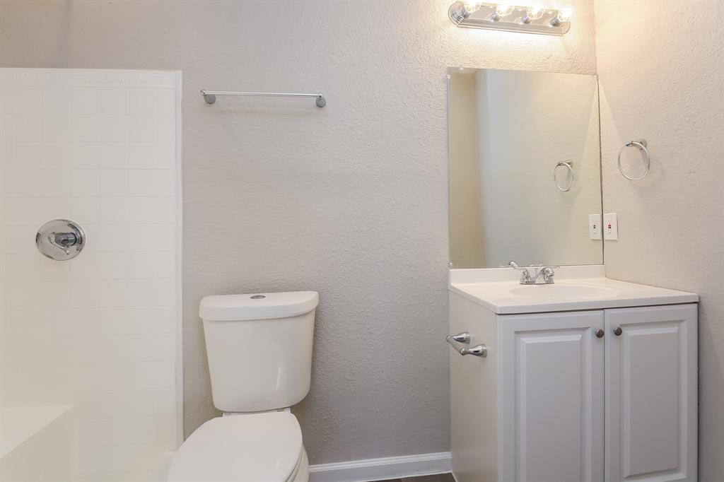 8209 Quail Glenn Court Rowlett, TX 75089 - Photo 14 of 16 a bathroom with a toilet a sink and mirror