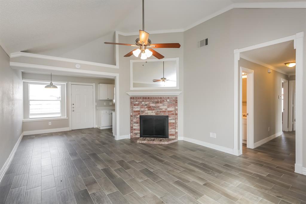 8209 Quail Glenn Court Rowlett, TX 75089 - Photo 3 of 16 an empty room with wooden floor fireplace and window