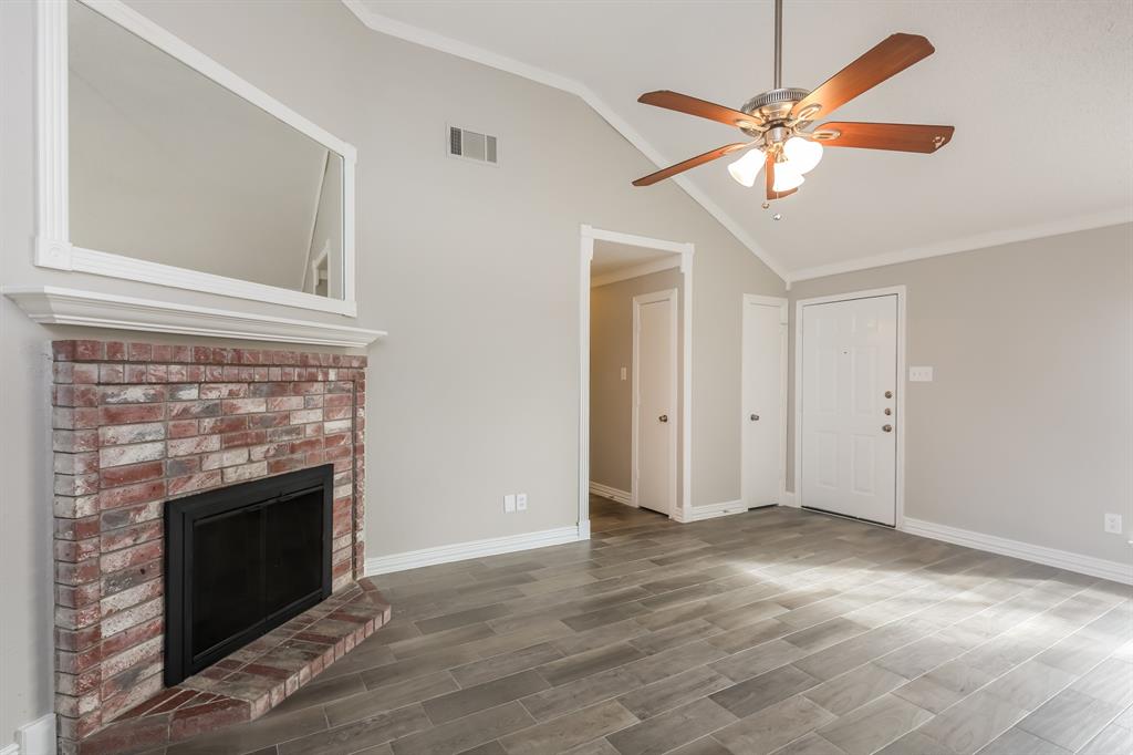8209 Quail Glenn Court Rowlett, TX 75089 - Photo 4 of 16 a view of an empty room with wooden floor and a fireplace