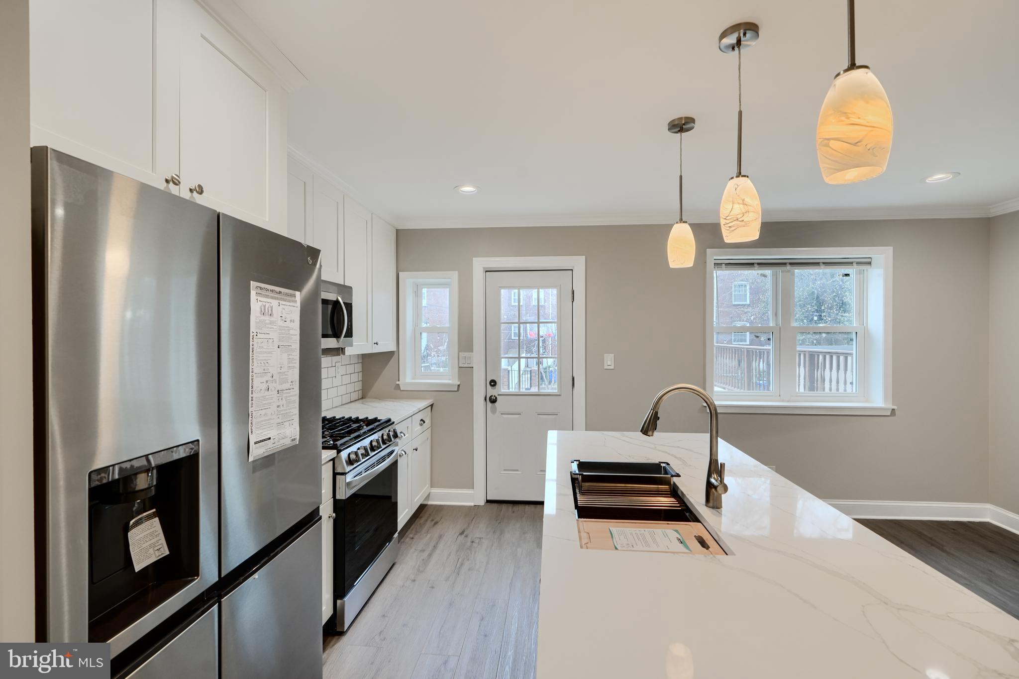 621 Ponca Street Baltimore, MD 21224 - Photo 12 of 38 a kitchen with stainless steel appliances a refrigerator and a stove
