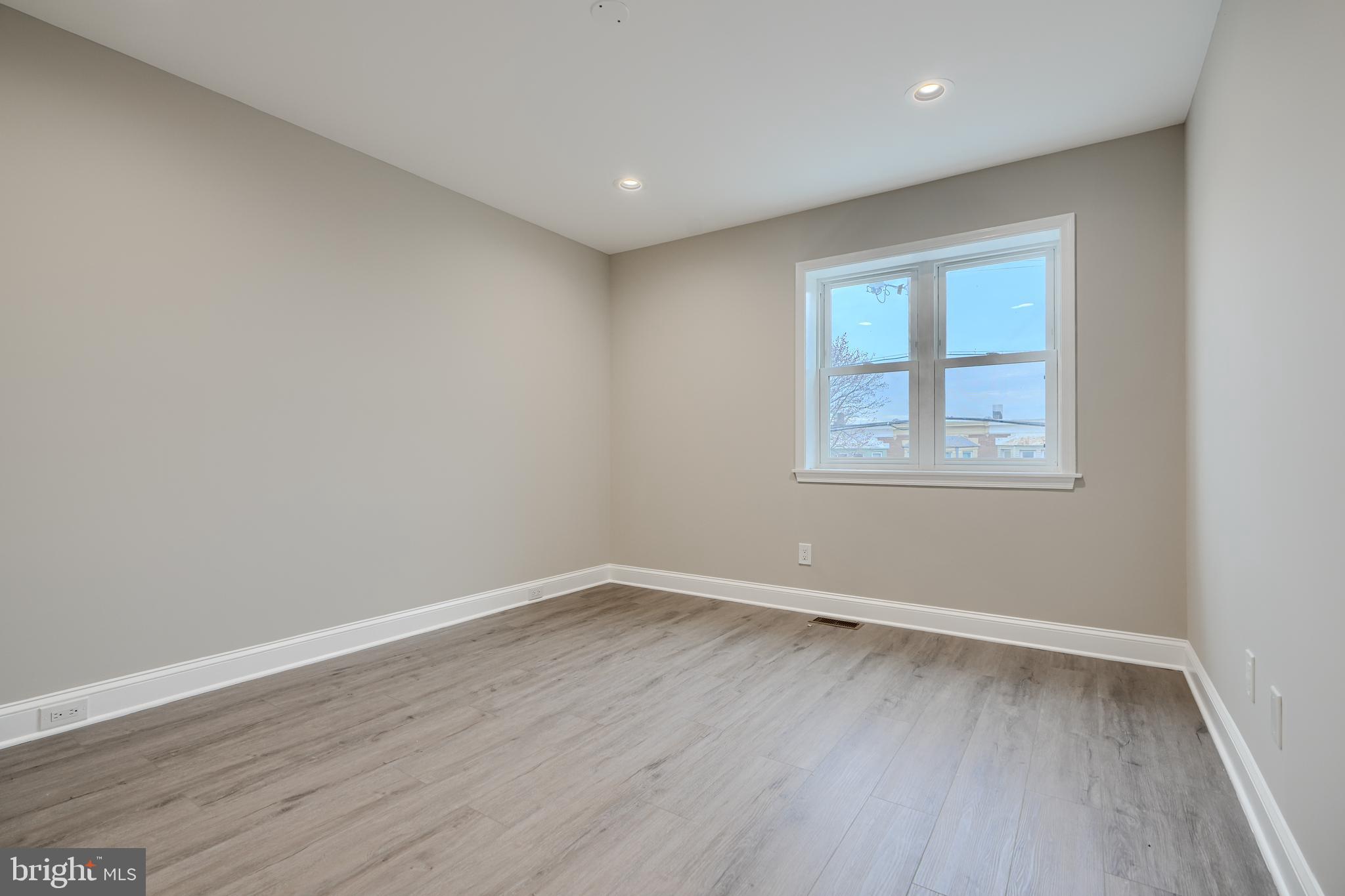 621 Ponca Street Baltimore, MD 21224 - Photo 22 of 38 an empty room with wooden floor and windows
