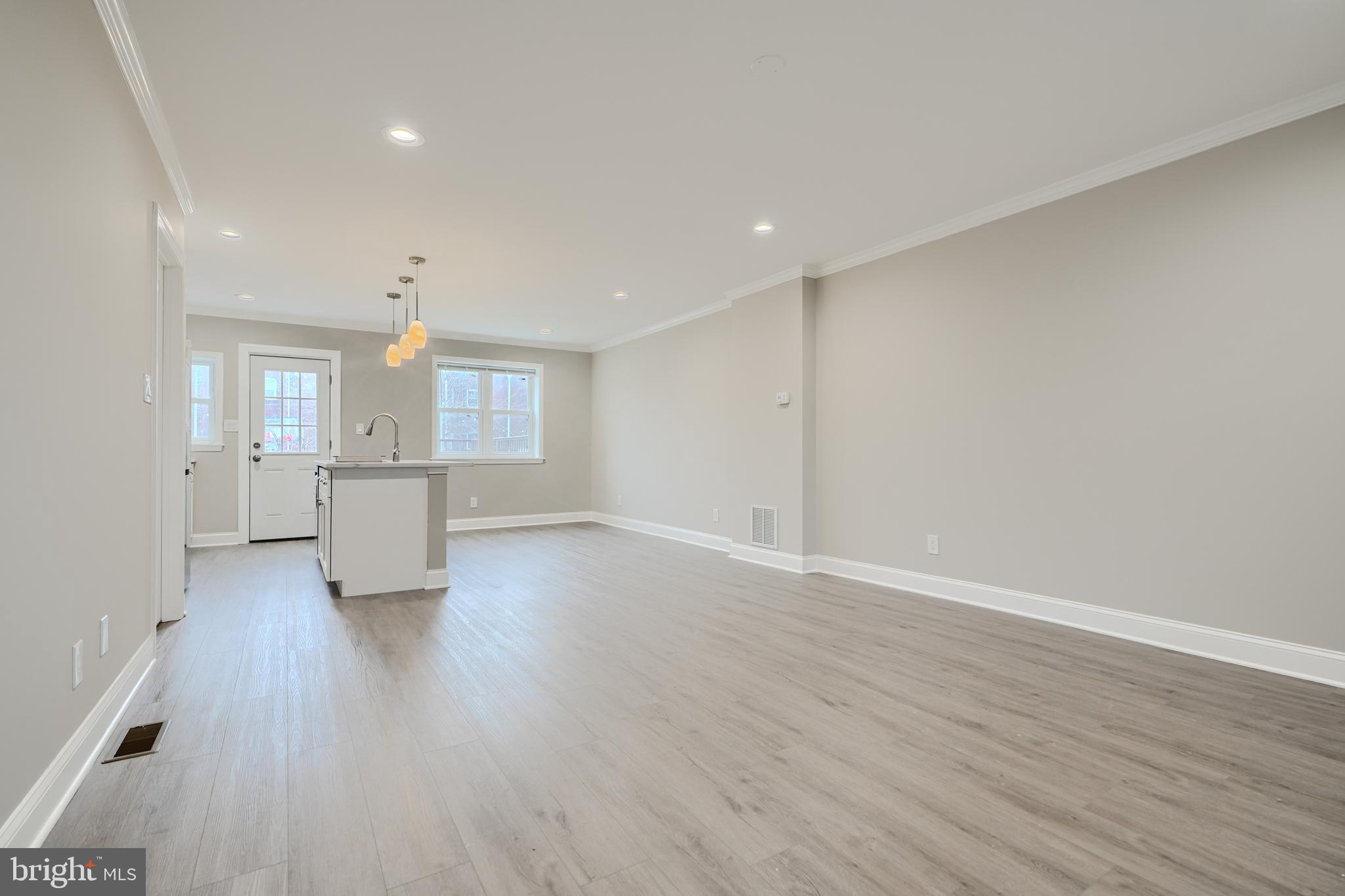 621 Ponca Street Baltimore, MD 21224 - Photo 5 of 38 an empty room with wooden floor and windows